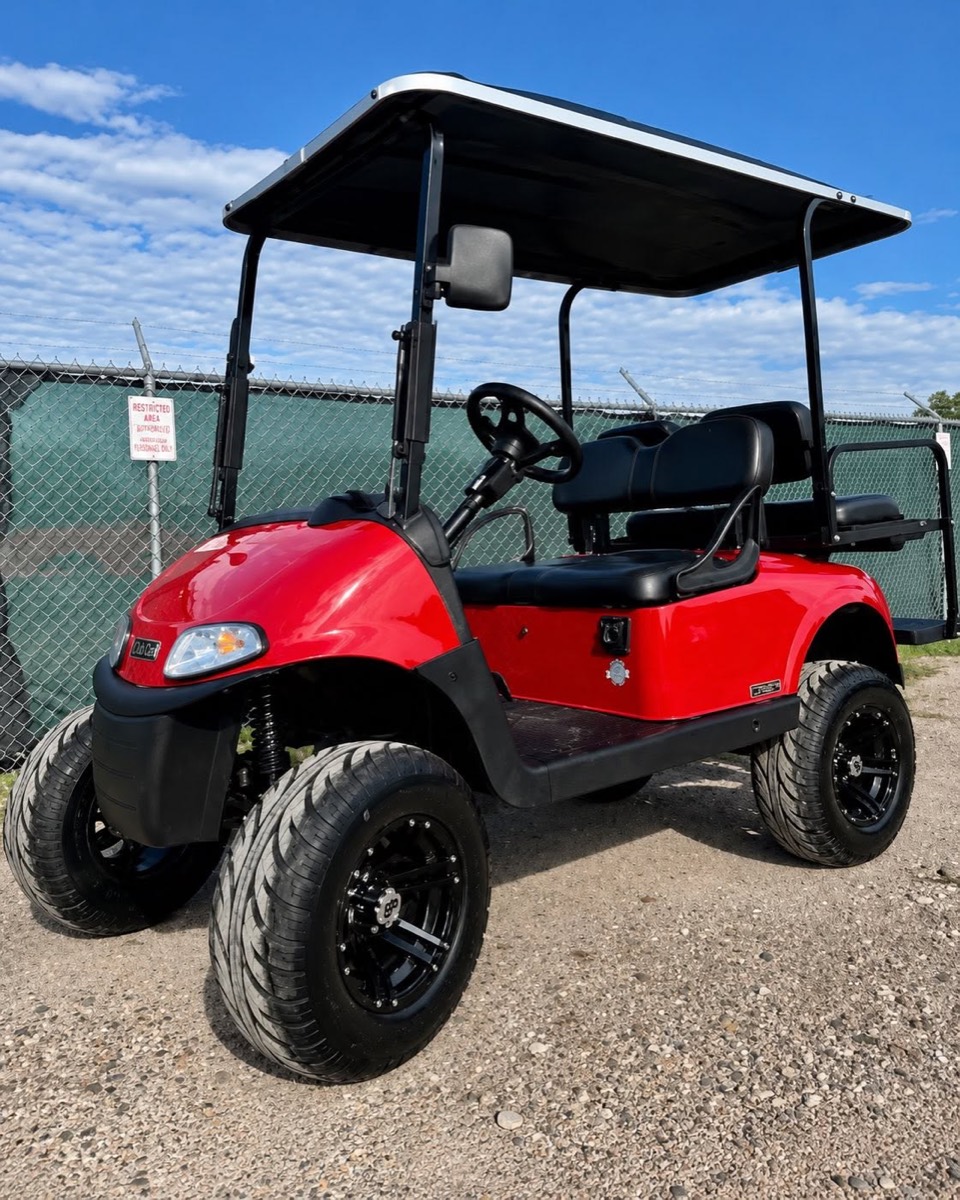 Red lifted EZGO golf cart with off-road tires