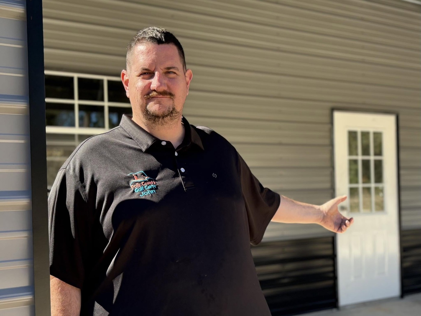 John, owner of Polk County Golf Carts, in front of the shop
