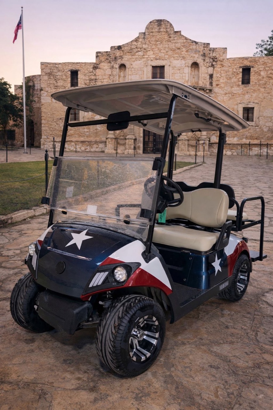 Yamaha golf cart with a Texas-flag wrap parked in front of the Alamo